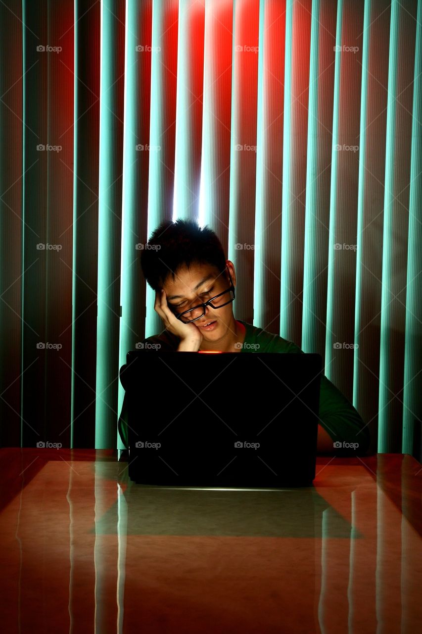 teenager sleeping in front of laptop computer