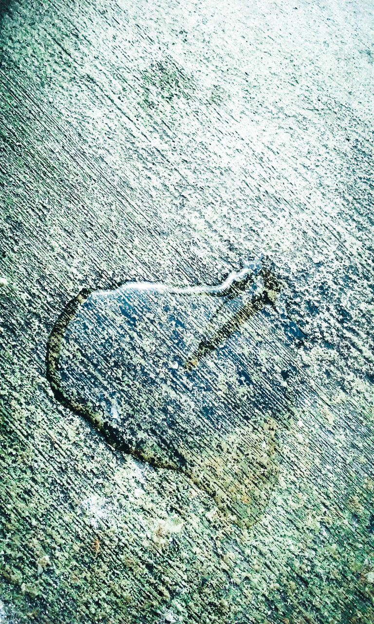 Heart-shaped water drop on street pavement
