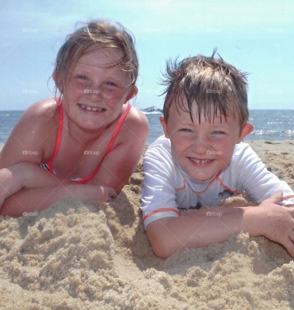 siblings at the beach. smiling siblings at sea shore