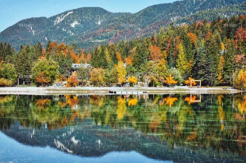 Background of scenic view of the autumn mountains landscape reflection in the Lake Jasna, Slovenia.