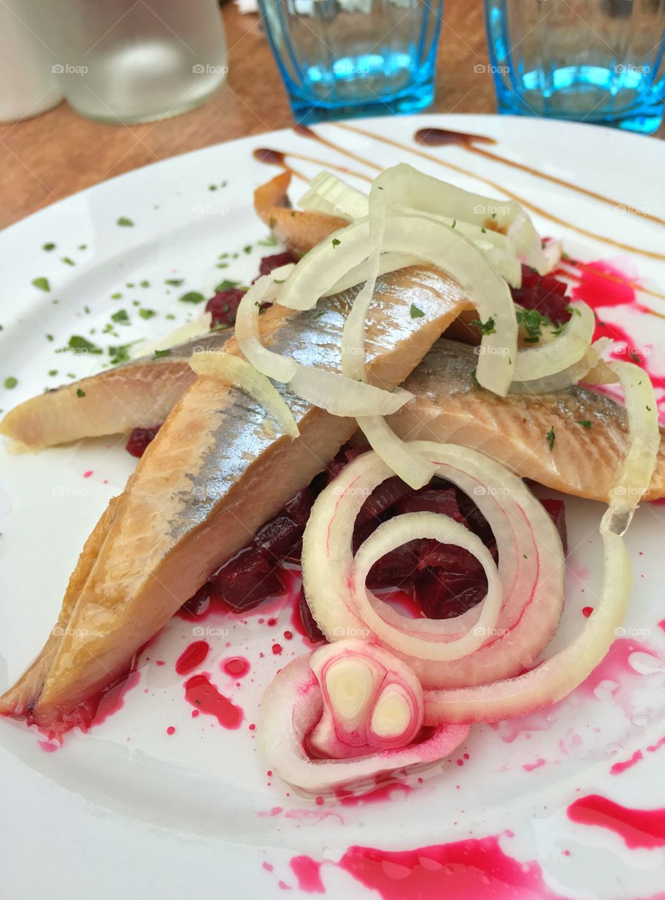 Delicious starter with fresh herring, beets and onion