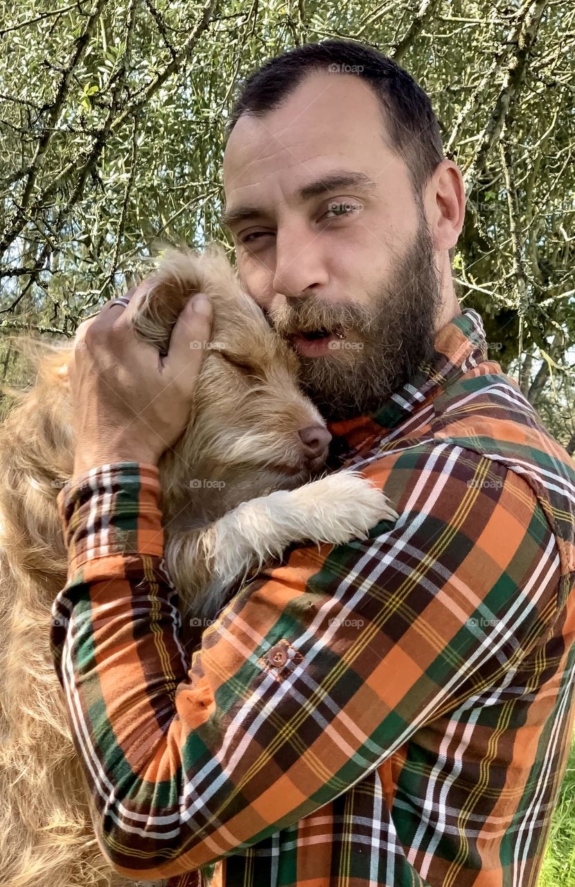 Portrait of Kevin and Effy the dog cuddling in the garden