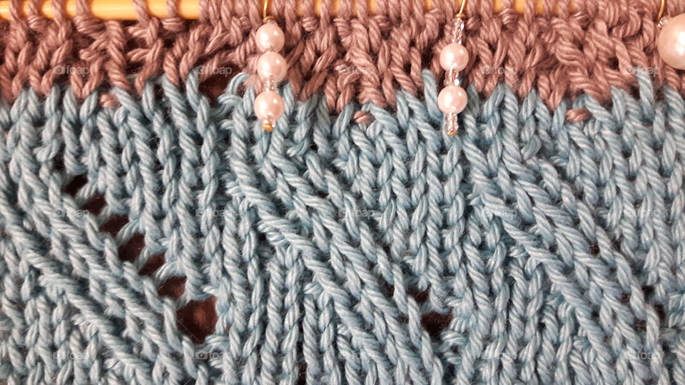 blue and beige waved with pearl stitch markers and wooden needles