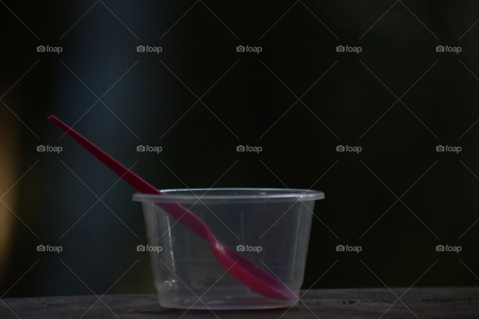 plastic cup with rose coloured spoon