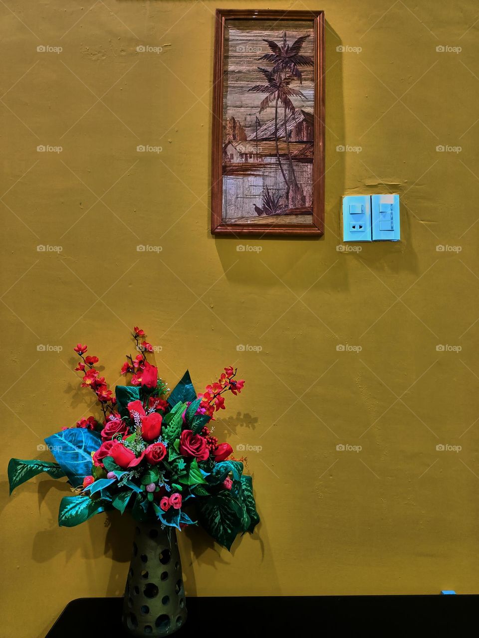 Interior room in yellow wall with single plant and single picture frame. Light background with copy space.