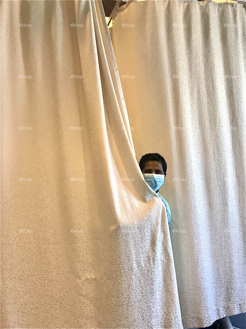 Masked person behind the curtain
