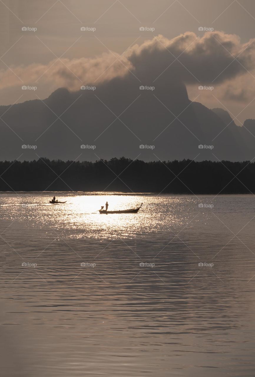 Beautiful Sunrise moment above silhouette of boat in sea