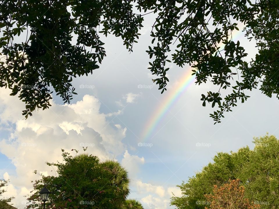 Rainbow and clouds at sunset after storm