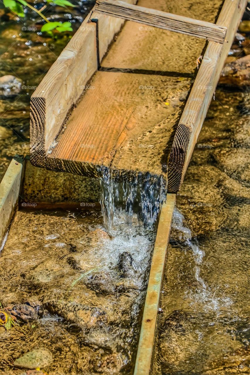 Vintage gold panning water slough with water cascading down on a stream hoping to make that big gold discovery in Jamestown California 