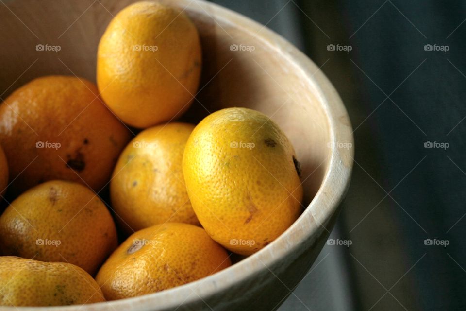 Orange fruits in the wooden bowl