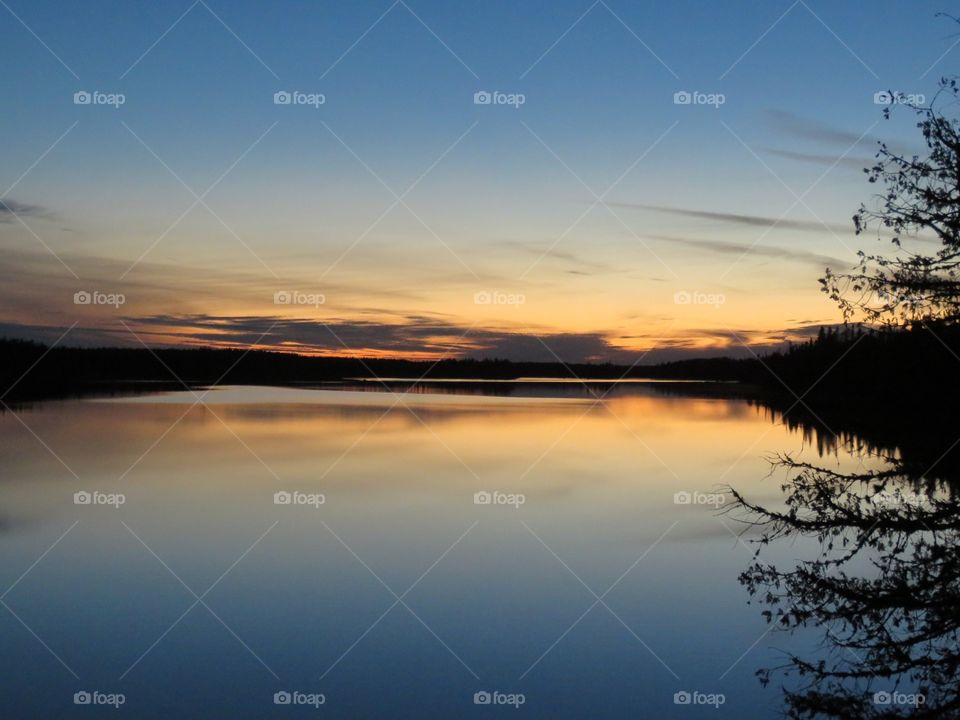 A scenic sunset reflected in the Little Current River in northern Ontario, Canada. 