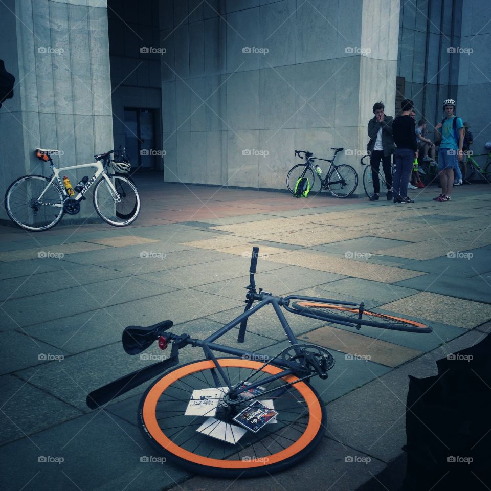 Grey brakeless fixie bike with orange wheels lying