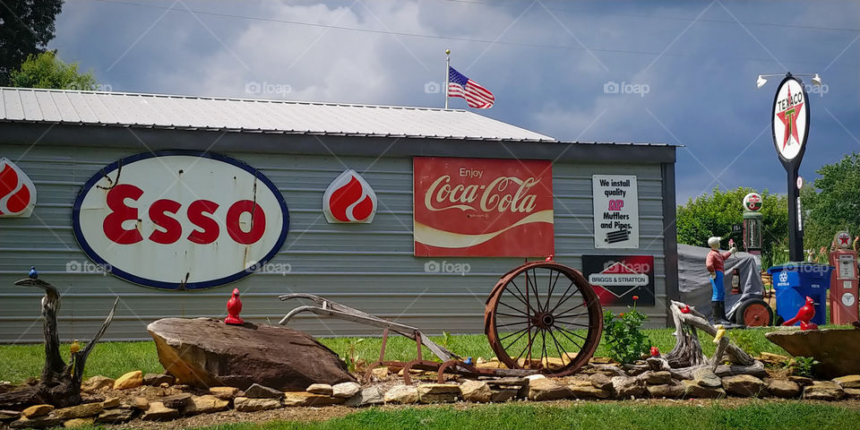 Flag flying over tin country shop. Decorated in signs.