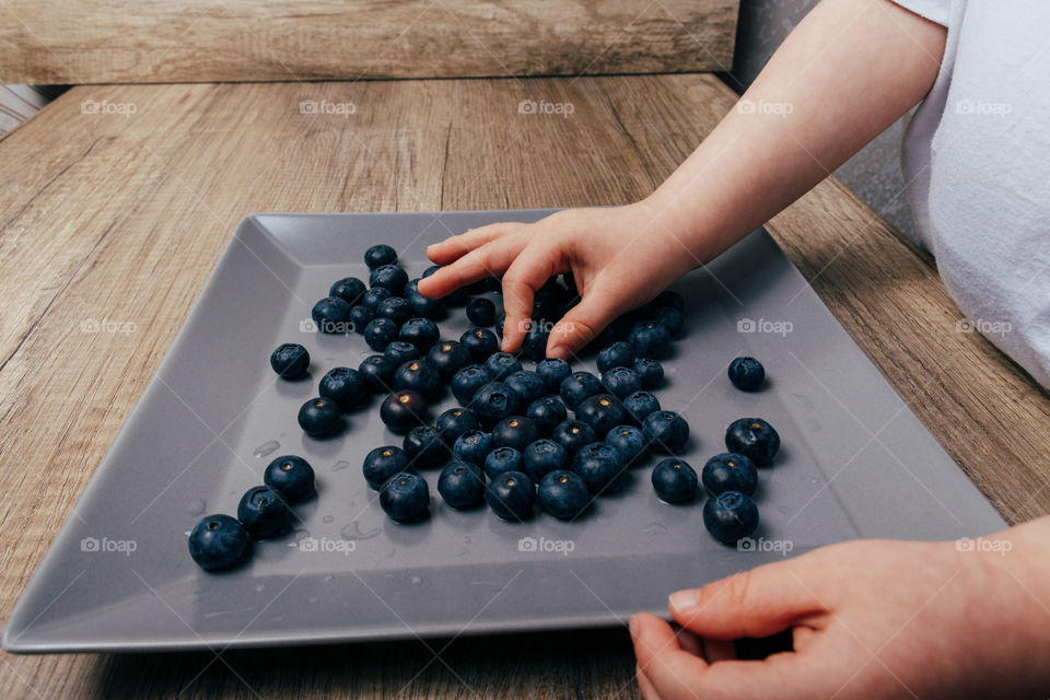 Boys hands and blueberries