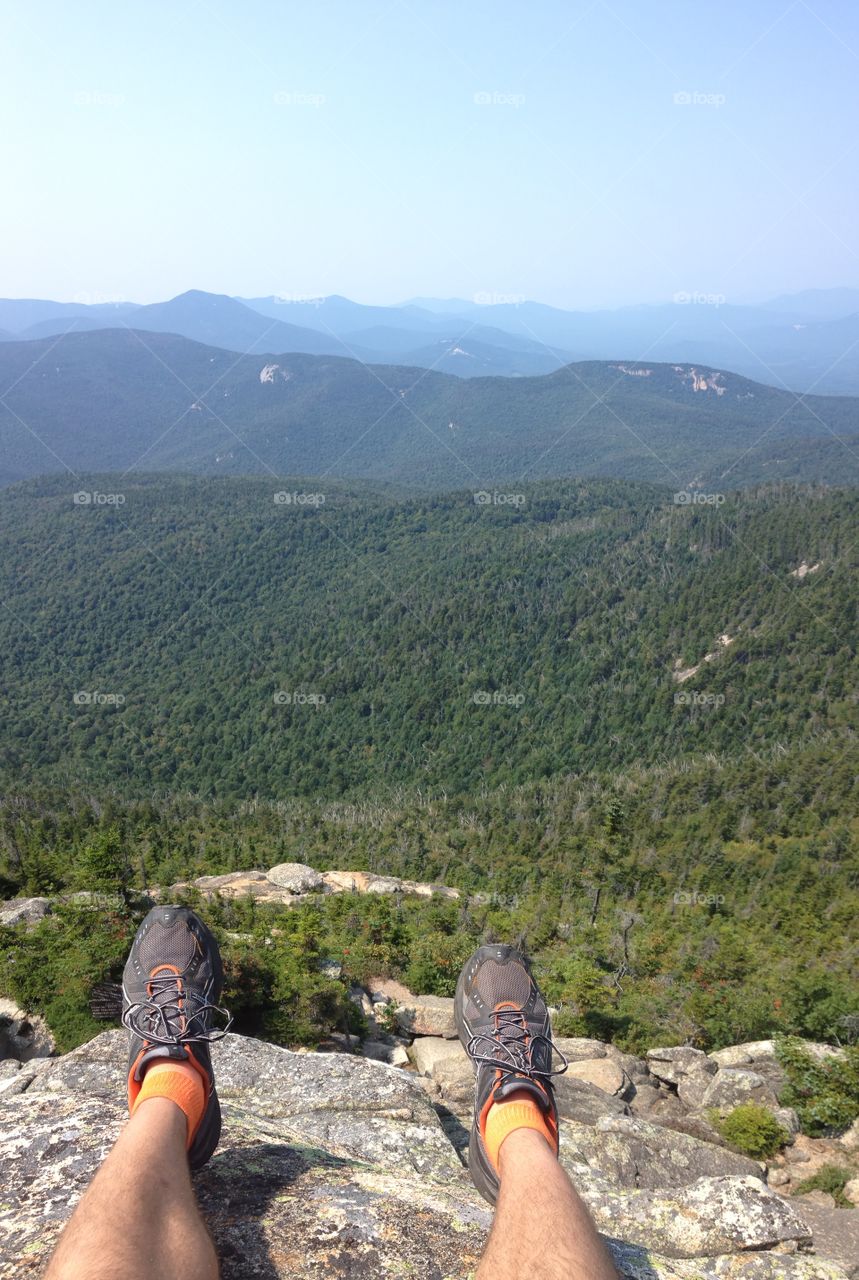 Hanging me feet over the edge of the top of Mount Chocorua in the white top mountains of New Hampshire 