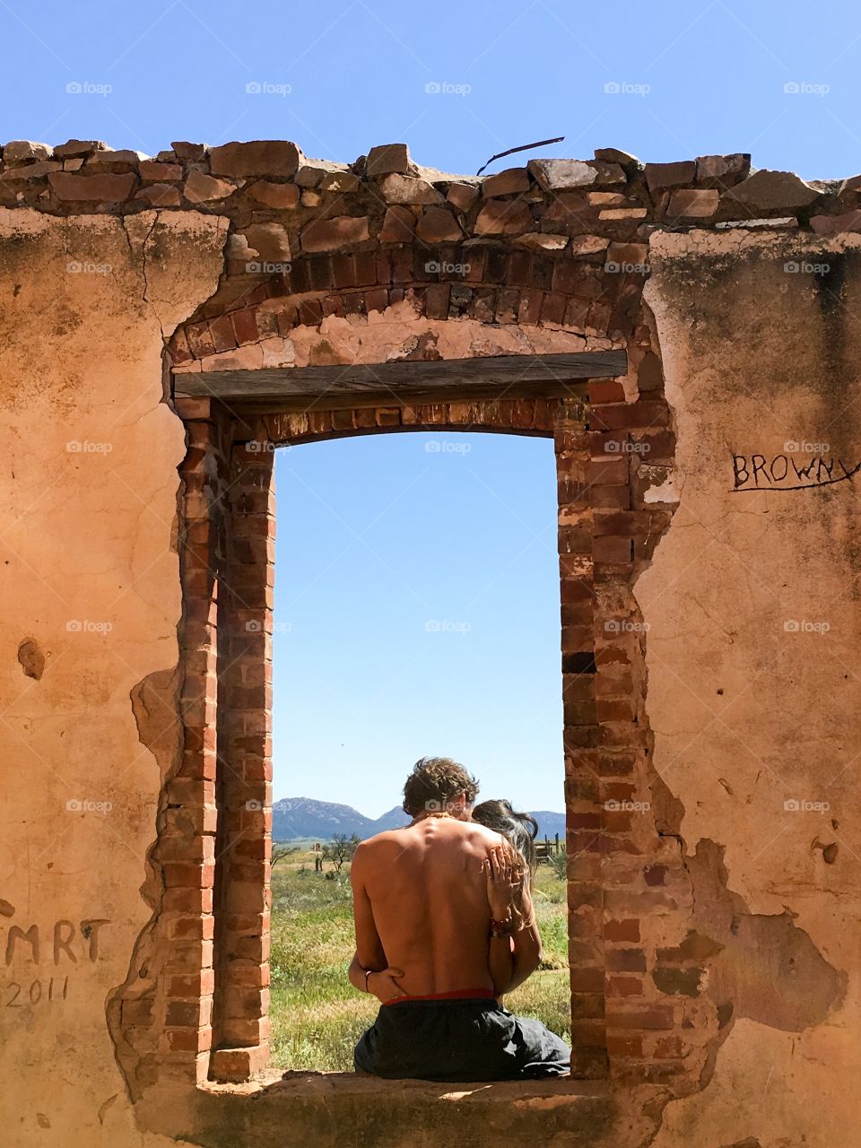 Young couple in an old settlers stone ruin in south Australia's Flinders Ranges area