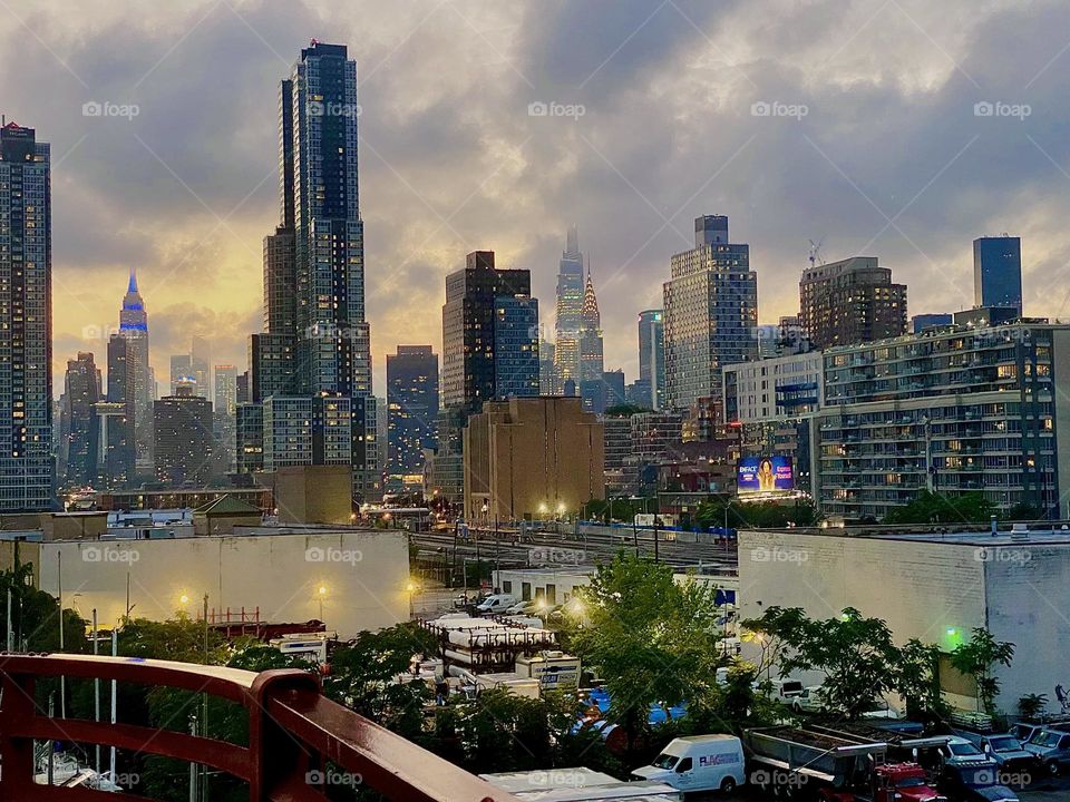 An assembly of NYC skyscrapers rise up into the cloud filled heavens above „Long Island City“, Queens at „Newtown Creek“ by the „Pulaski Bridge“. 2023. Hypnotic Productions
