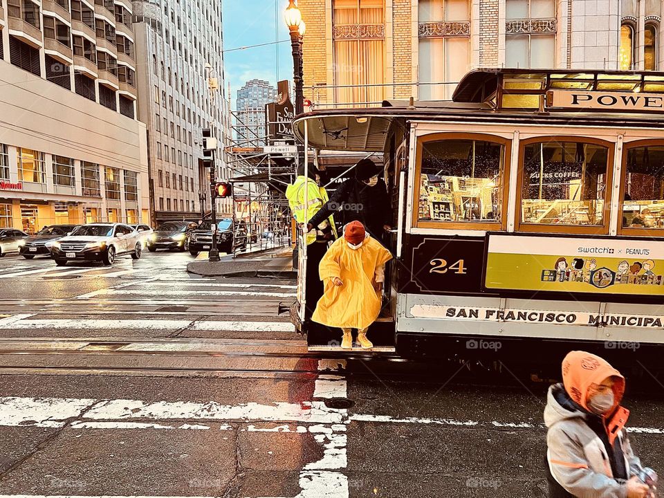 Kid getting off tram in San Francisco on rainy day commute 