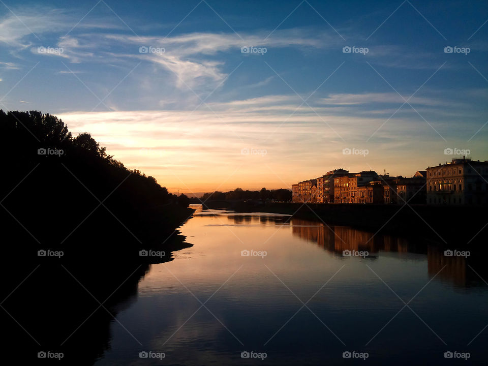 Sunset in Florence, Italy. Beautiful sunset scenery reflecting on the Fiume Arno river, taken from Ponte A. Vespucci