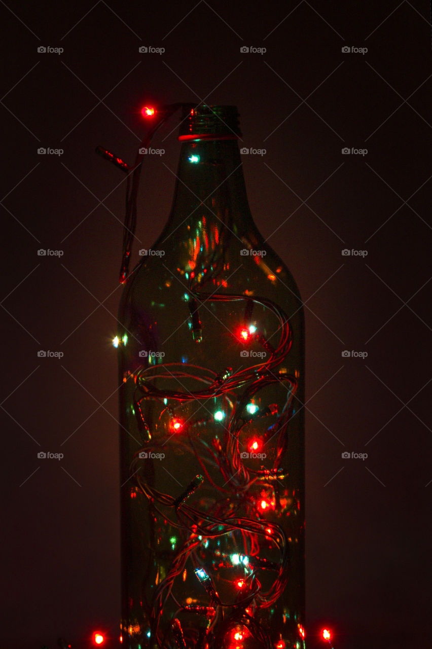 magic bottle concept.  glass bottle filled with shining garlands