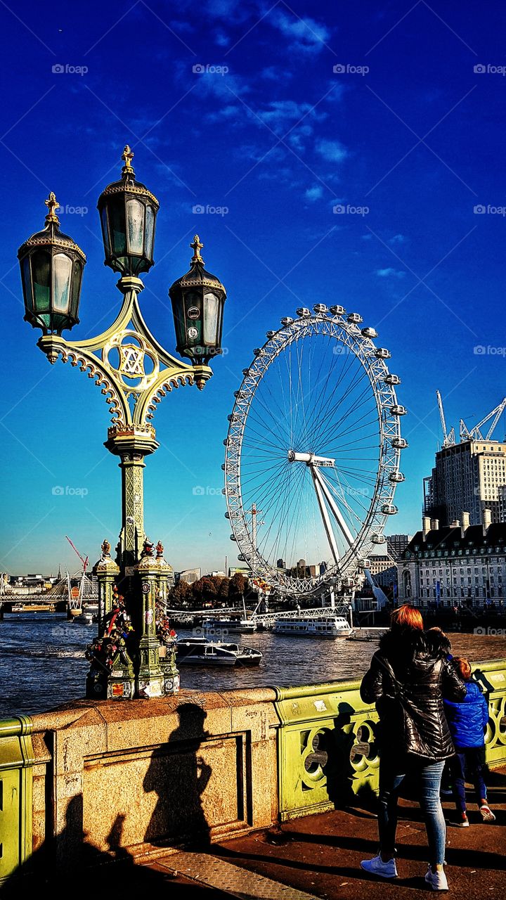 The London Eye from Westminster Bridge with decorative street lamps