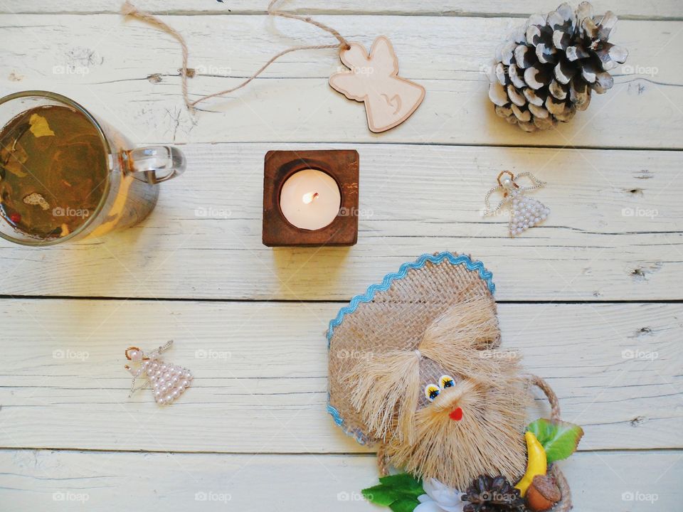 cup of tea, crafts, candle and an angel on the table