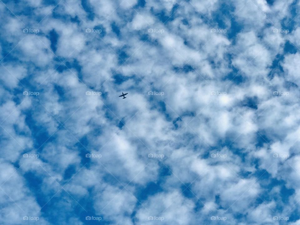 A blue sky and lot of clouds in between a aircraft 