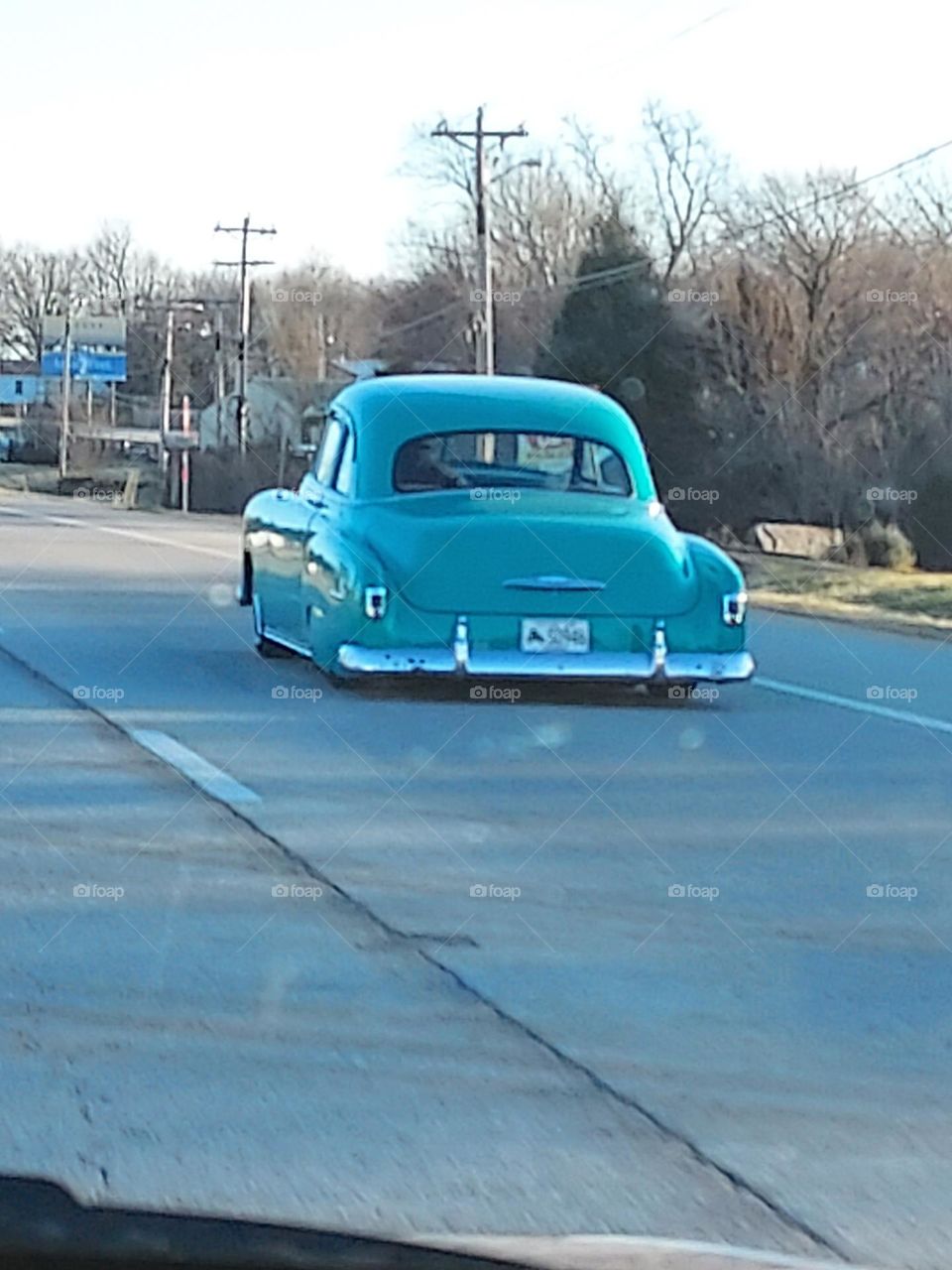 cruising down the road in style on a pretty perfect day,  must really be nice to own.