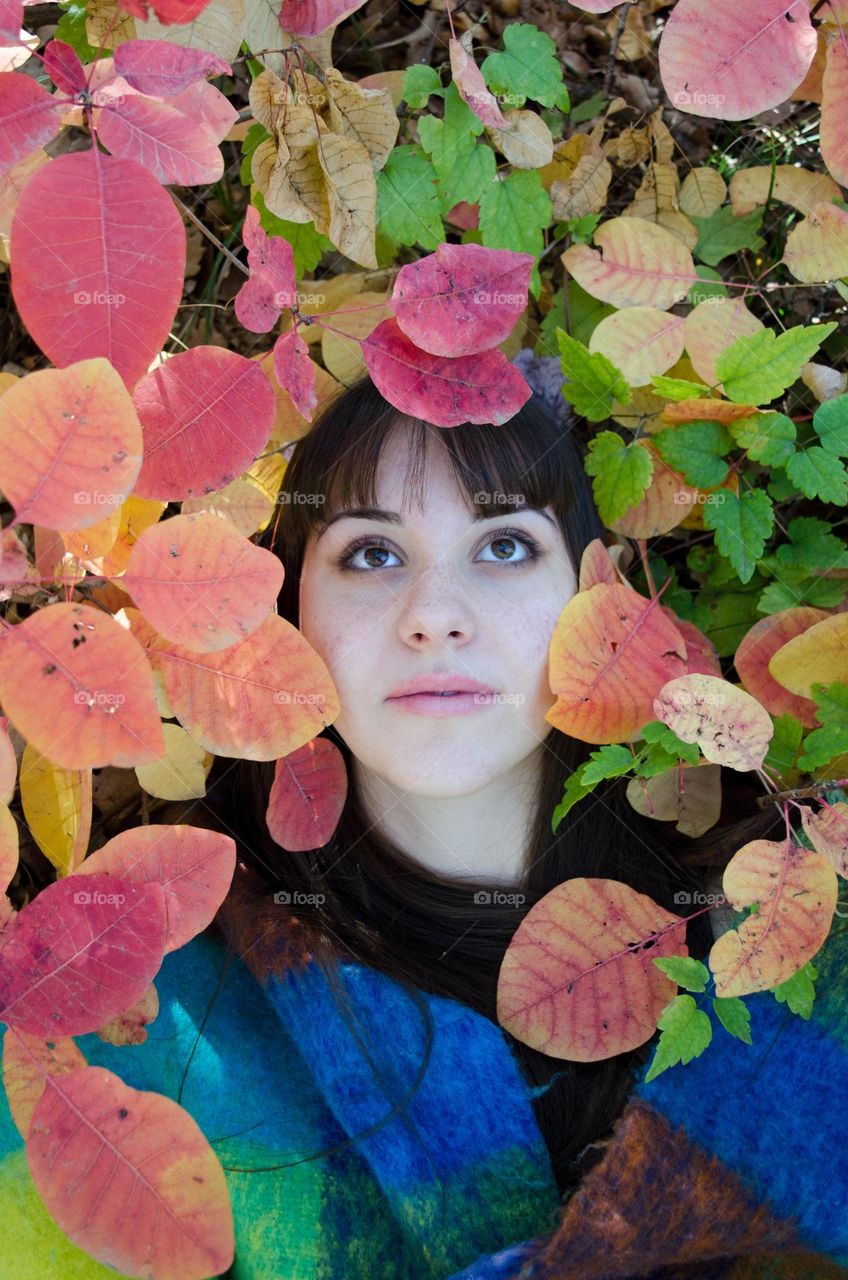 Portrait of beautiful young woman brunette on autumn background