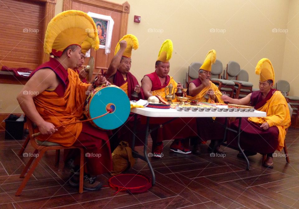 Group of monk sitting in traditional costume with musical instrument