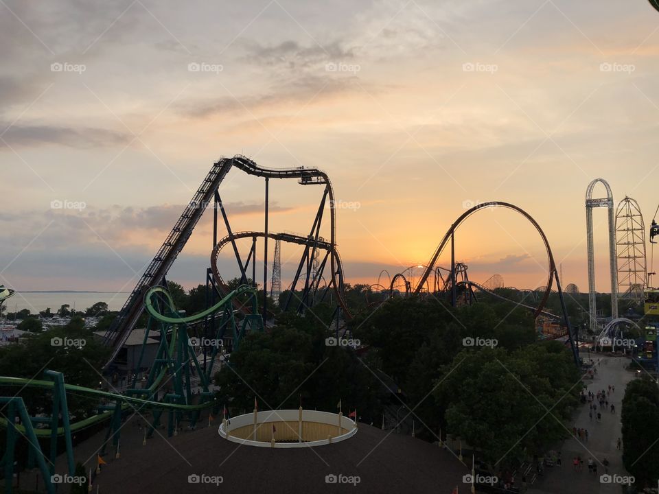 Sunset over Cedar Point Amusement Park showcasing Valravn, Raptor, and other roller coasters
