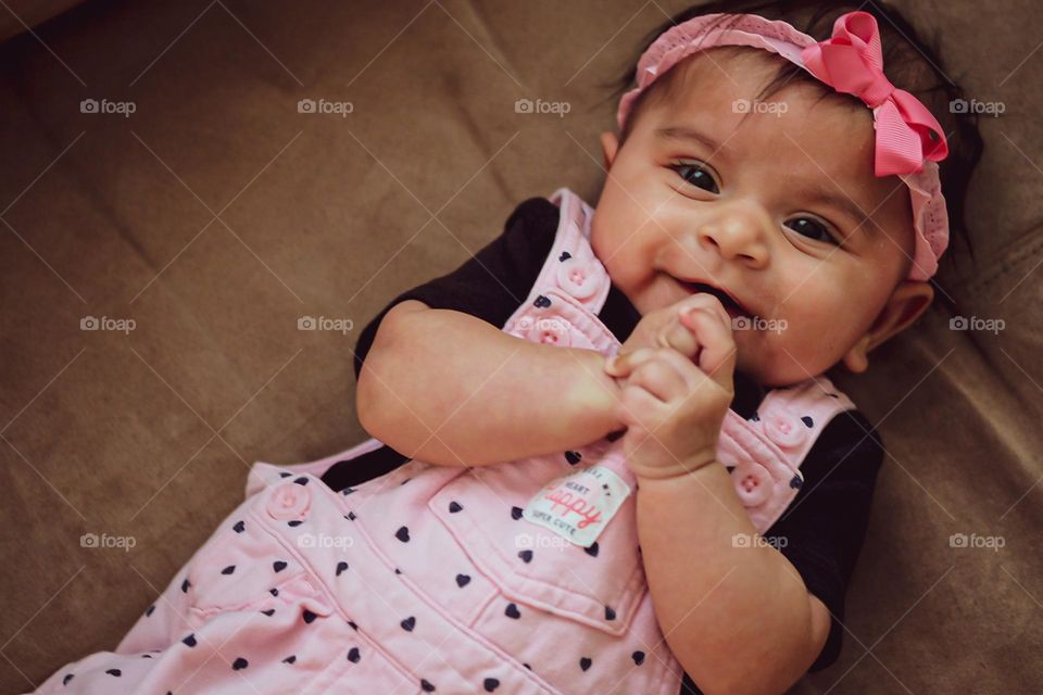 Baby girl clasping hands in happiness, joy in an infant’s face, baby girl expressing joy, happy baby clasps hands, baby is happy and excited to see mommy, baby shows emotion of happiness, emotion of happiness expressed 