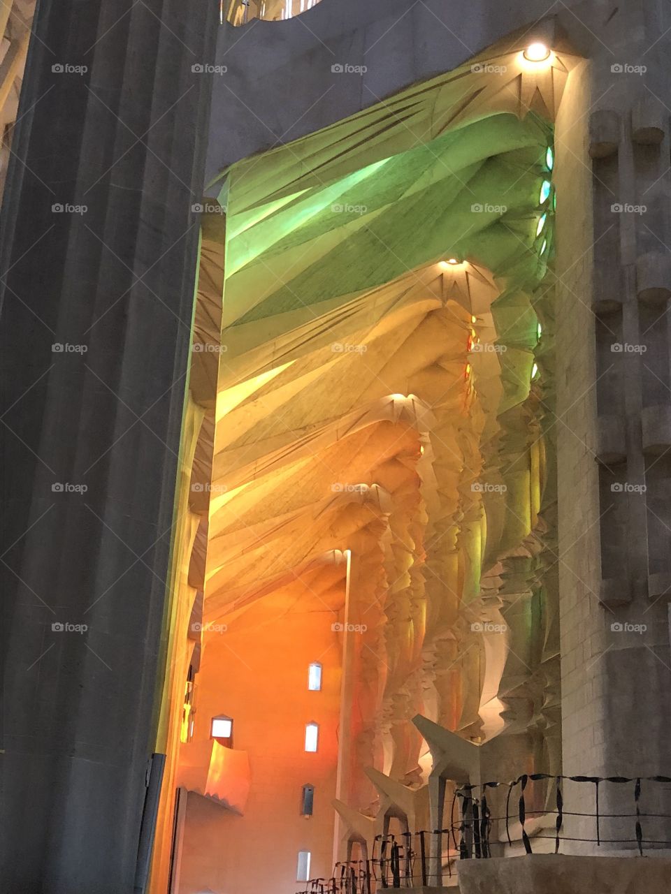 Floods of rainbow colored light streaming through the stained glass of the Gaudi Cathedral. 