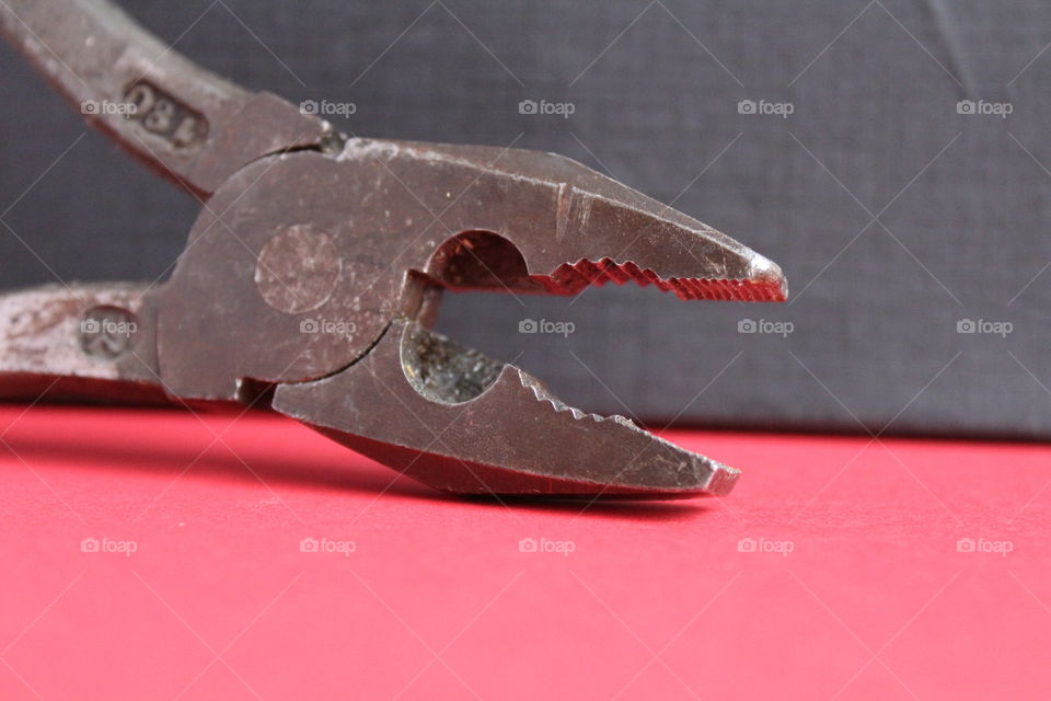 macro of pliers on red and black background