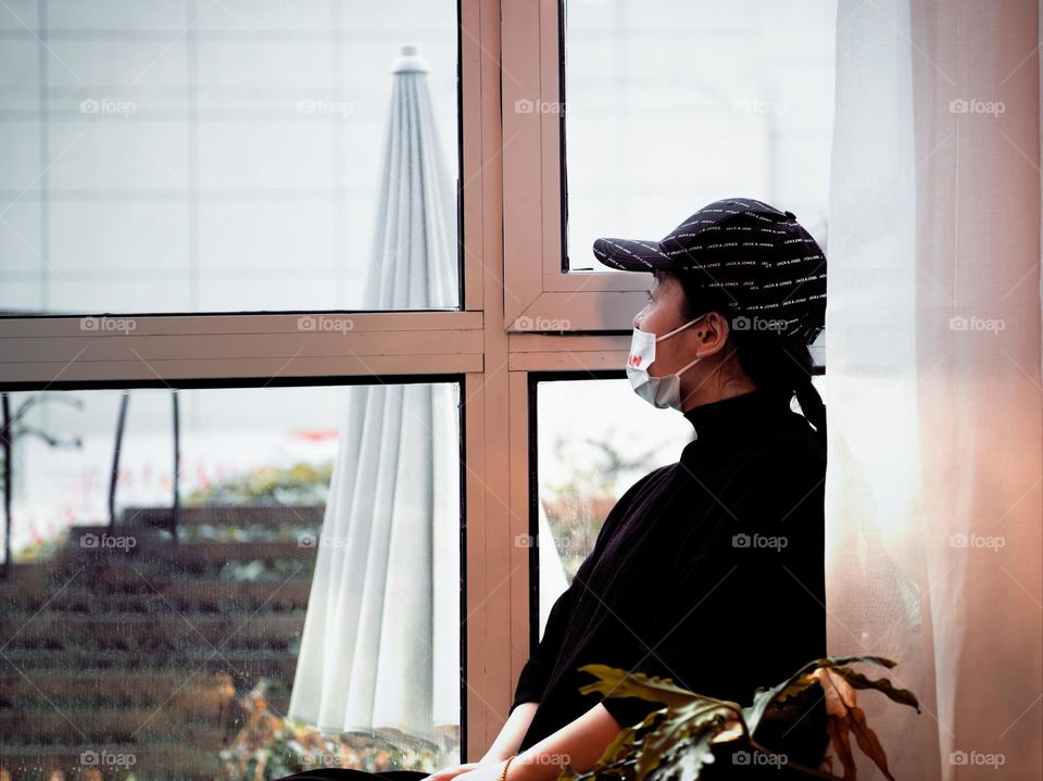 A woman is enjoying the view through the window.