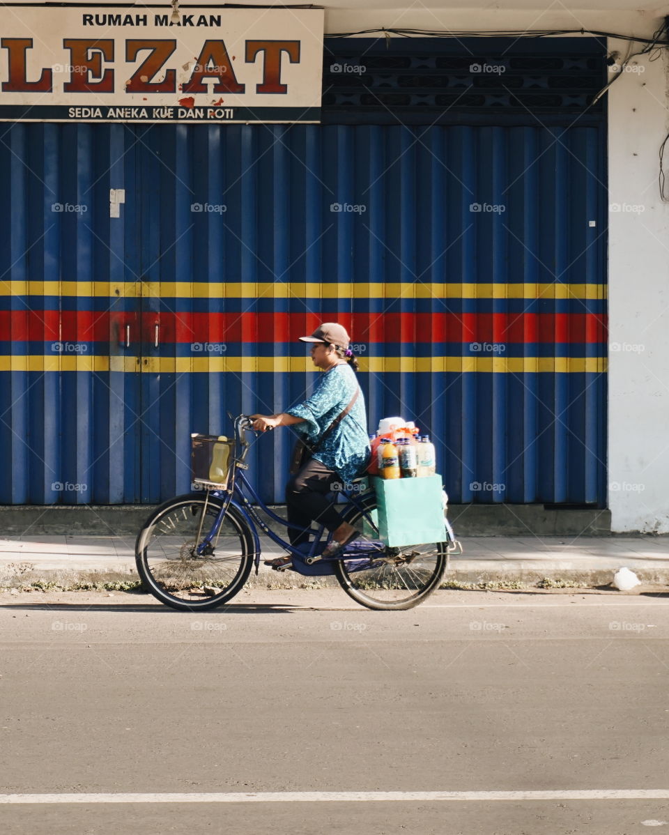 A woman is on her way working today,  ready to sell her traditional herbs beverage.