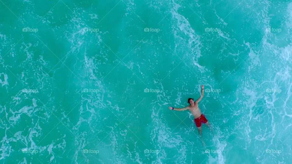 High angle view of man floating on sea