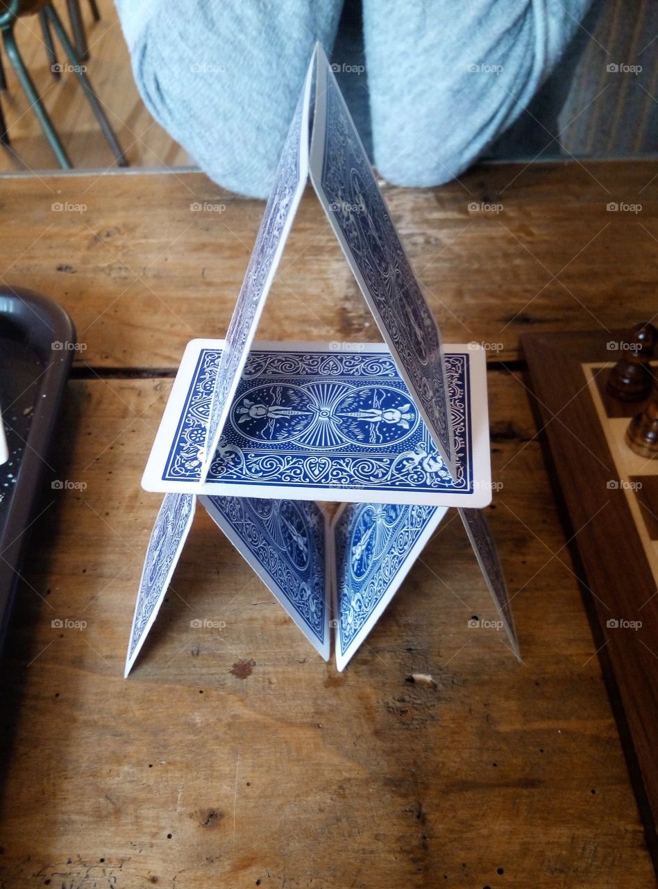 a castle of blue card on a wooden table. Vintage vibe