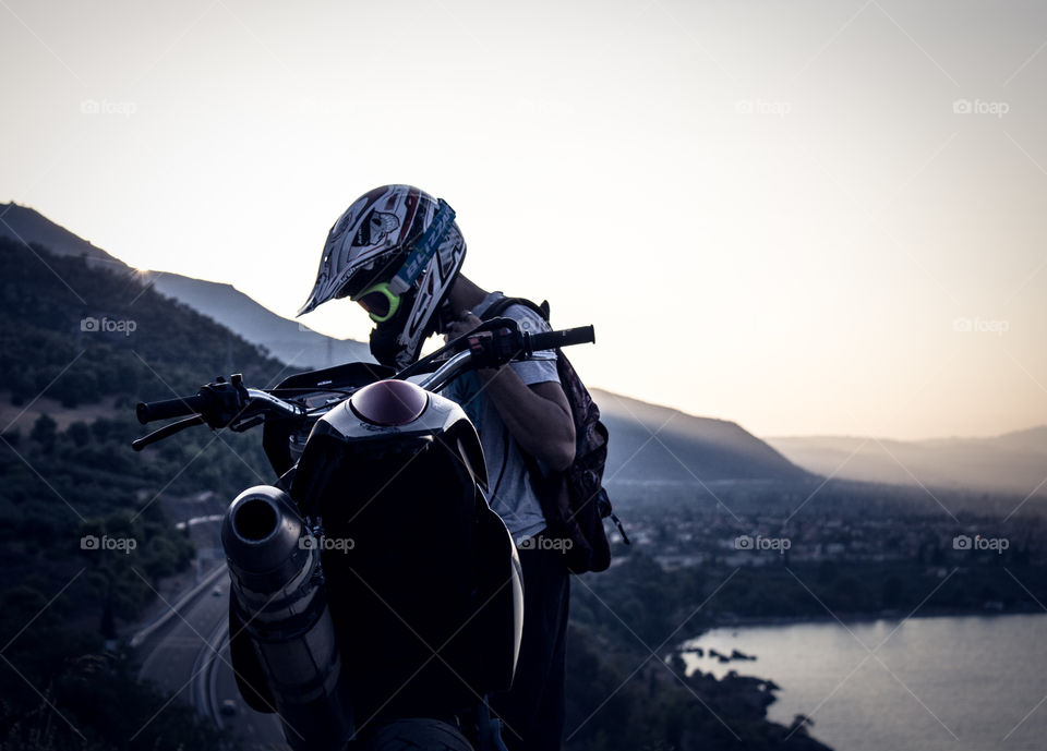 biker stops at a cliff with his motorcycle