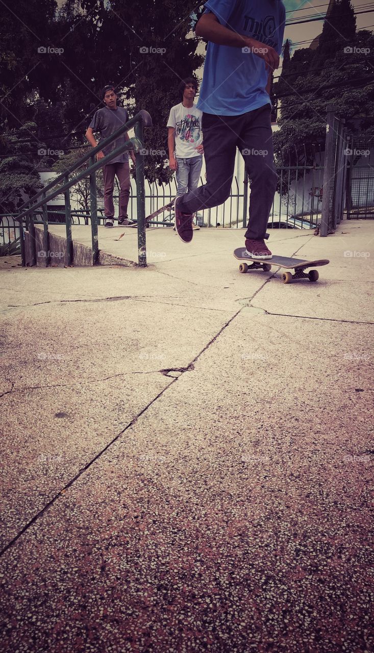 Boys observing another one skateboarding 