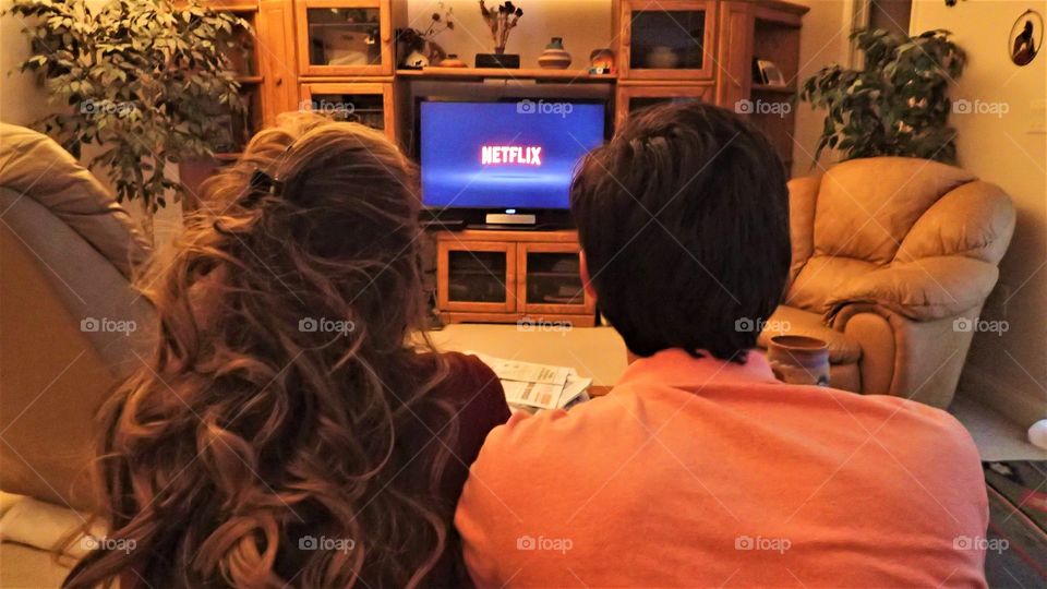 Date night with Netflix young couple enjoying a movie night at home