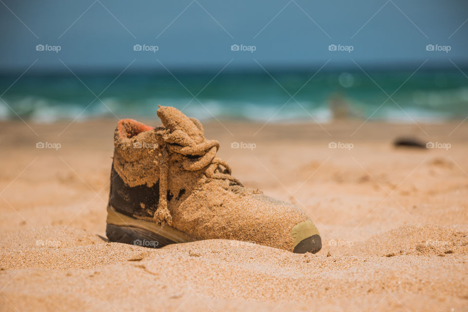 Close-up of a shoe covered with sand
