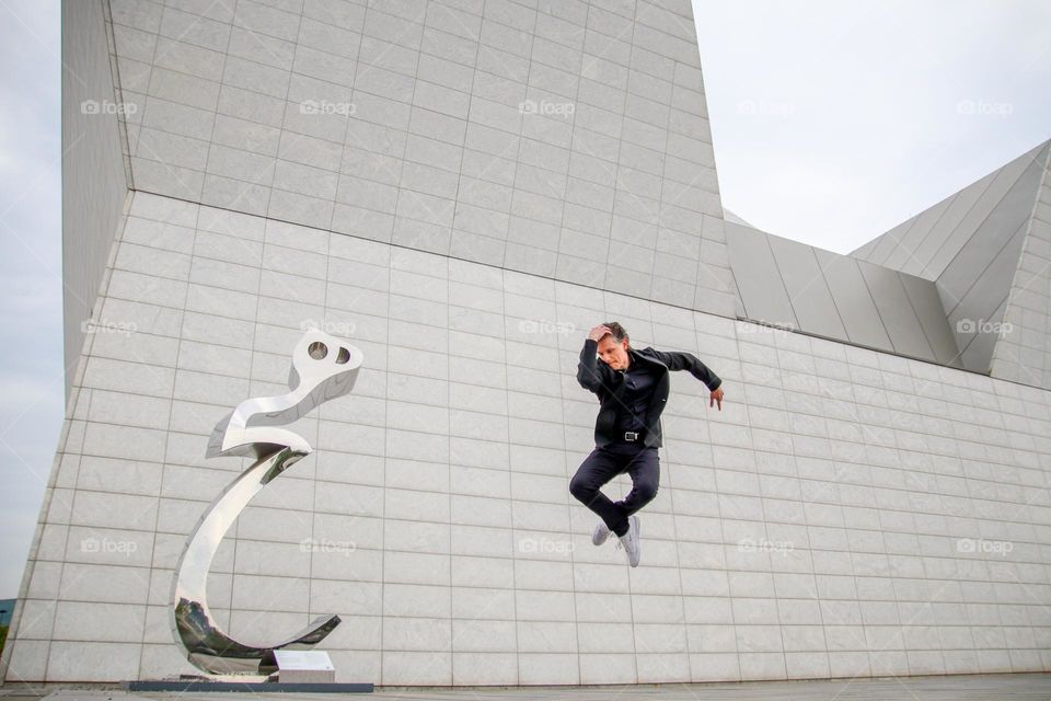 Man in black is dancing outdoors