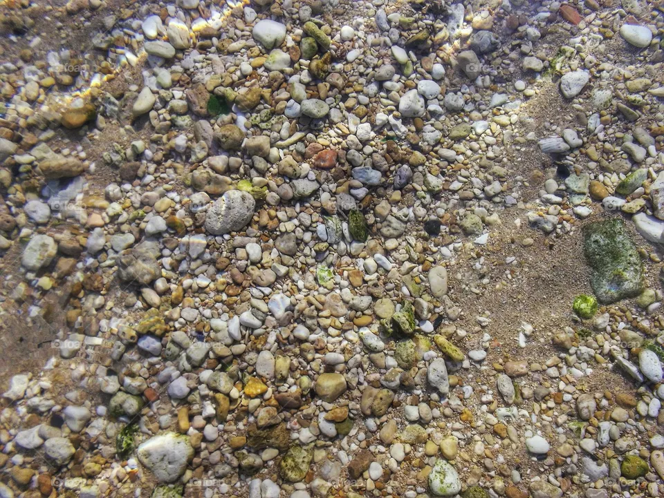 crystal clear water with stones and sand