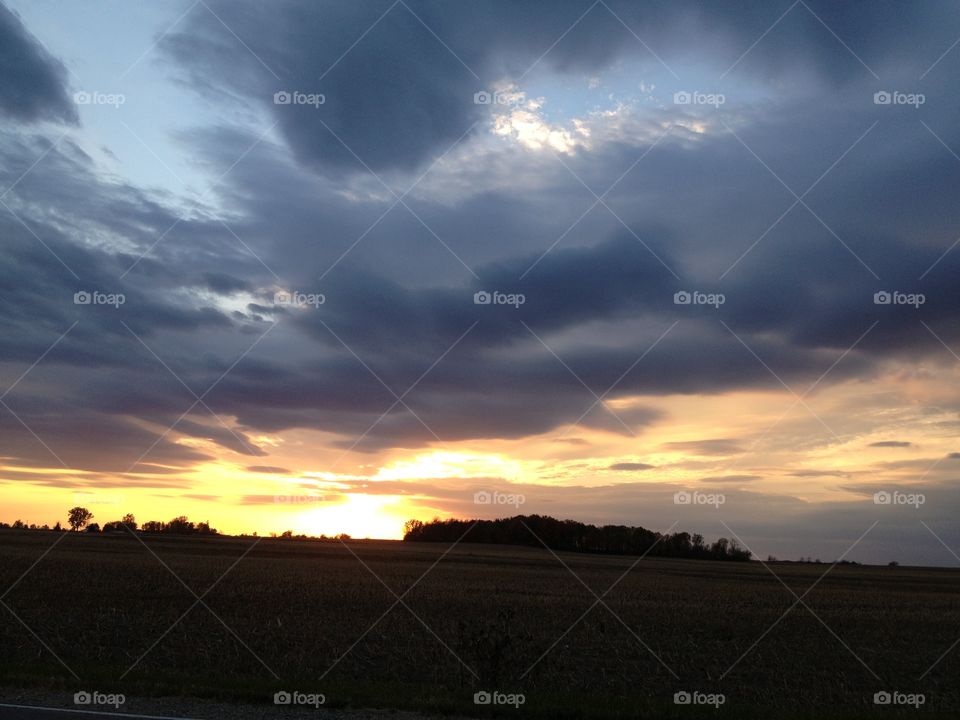 Sunset over land. Sunset over land with yellow clouds transitioning to purple 