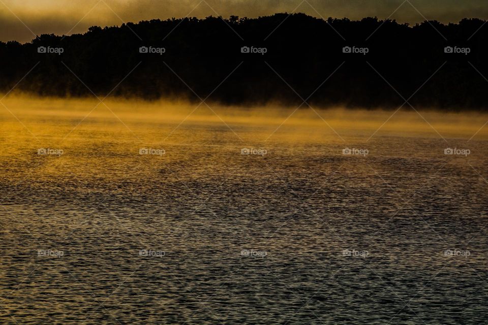 sunrise over a mist covered lake