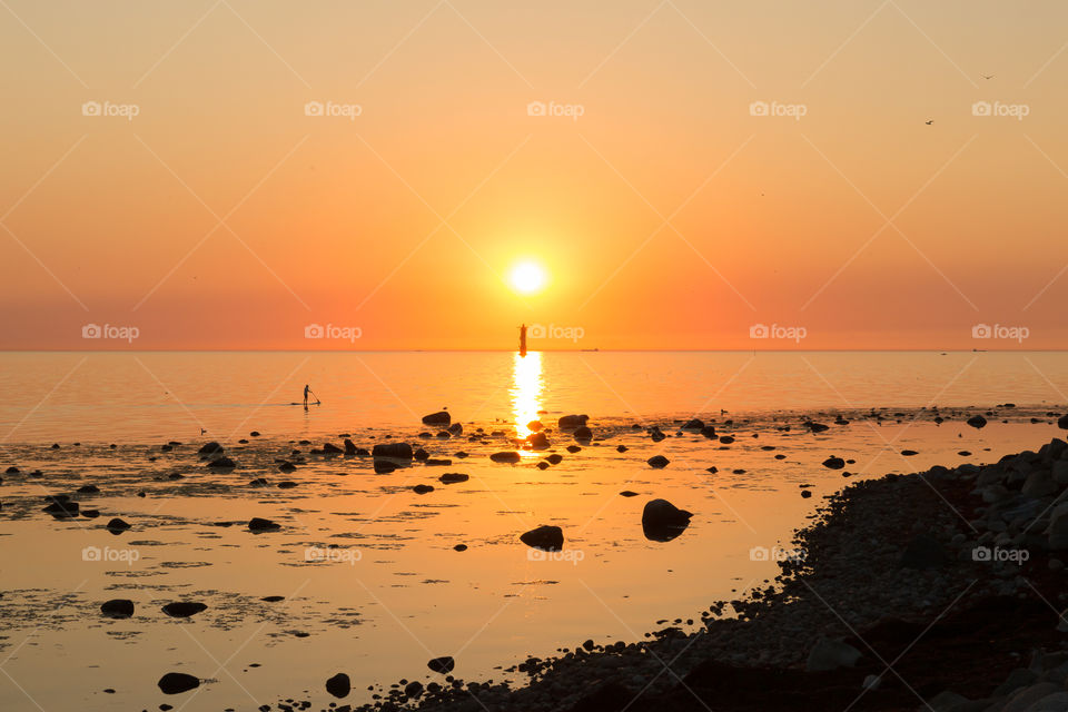By the ocean at golden hour, sunset with warm colors 