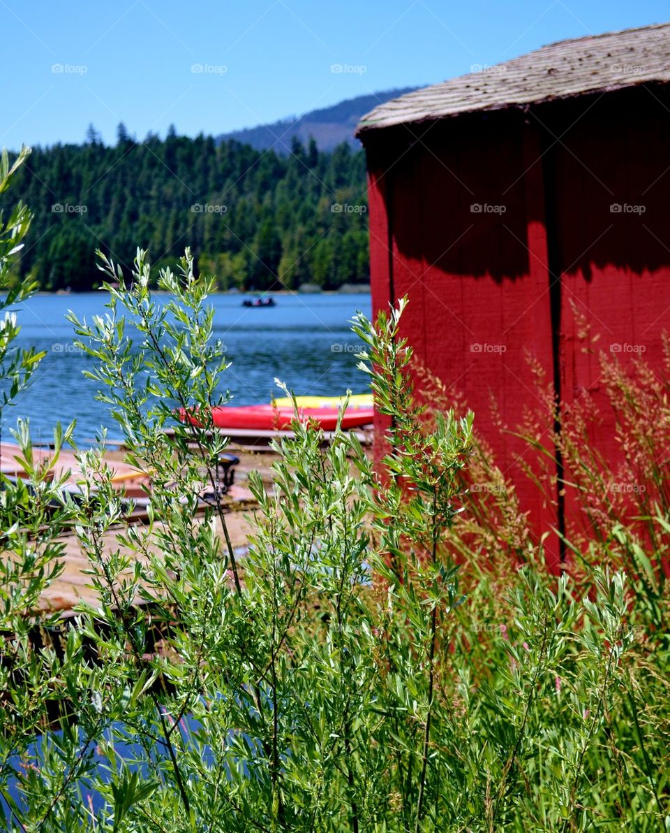Boats and red boathouse at lake