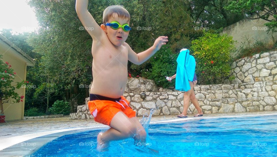 boy jumps in the swimming pool 