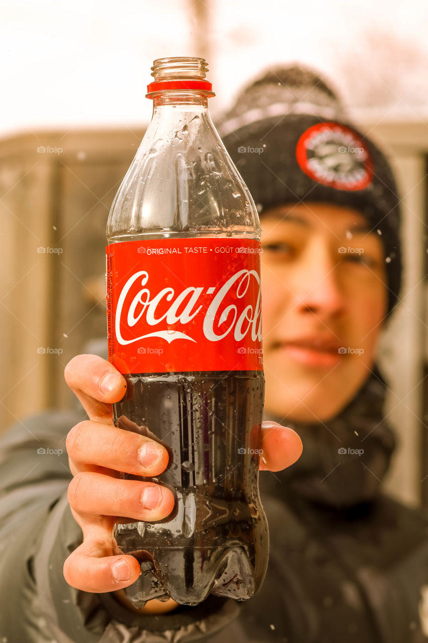 Happy teenager with a bottle of coca cola